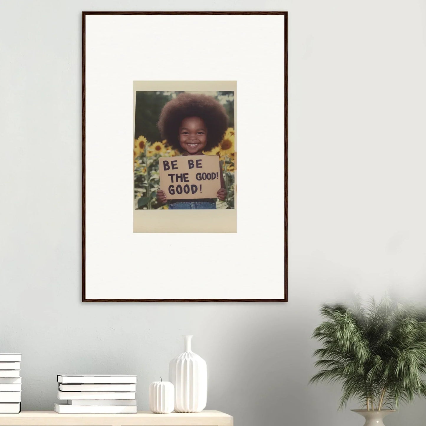 Framed wall art featuring BE THE GOOD text on a vibrant sunflower’s gentle whisper backdrop