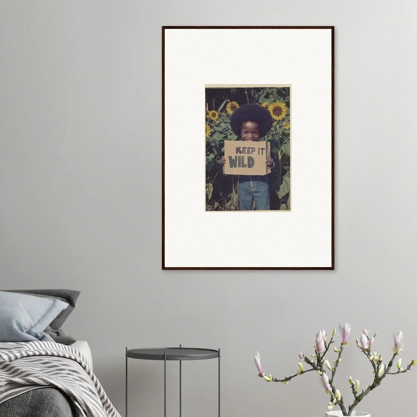 Framed photograph of a person with a Keep It Wild sign in sunflowers for room decoration