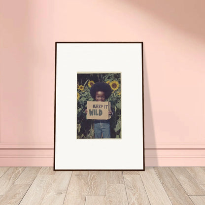 Framed photo of person with KEEP IT WILD sign in sunflowers for room decoration