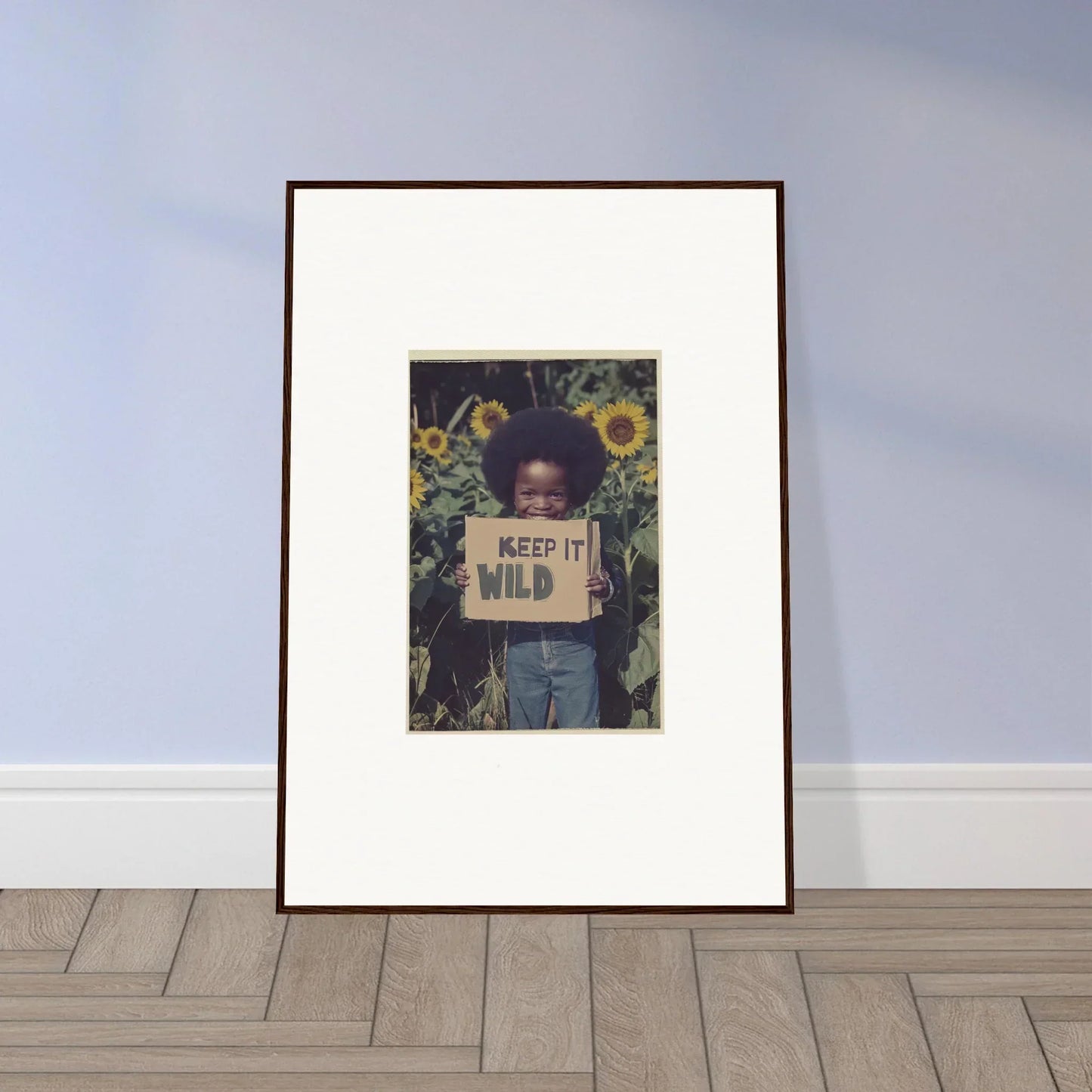 Framed photo of a child with a Keep it Wild sign in sunflowers for room decoration