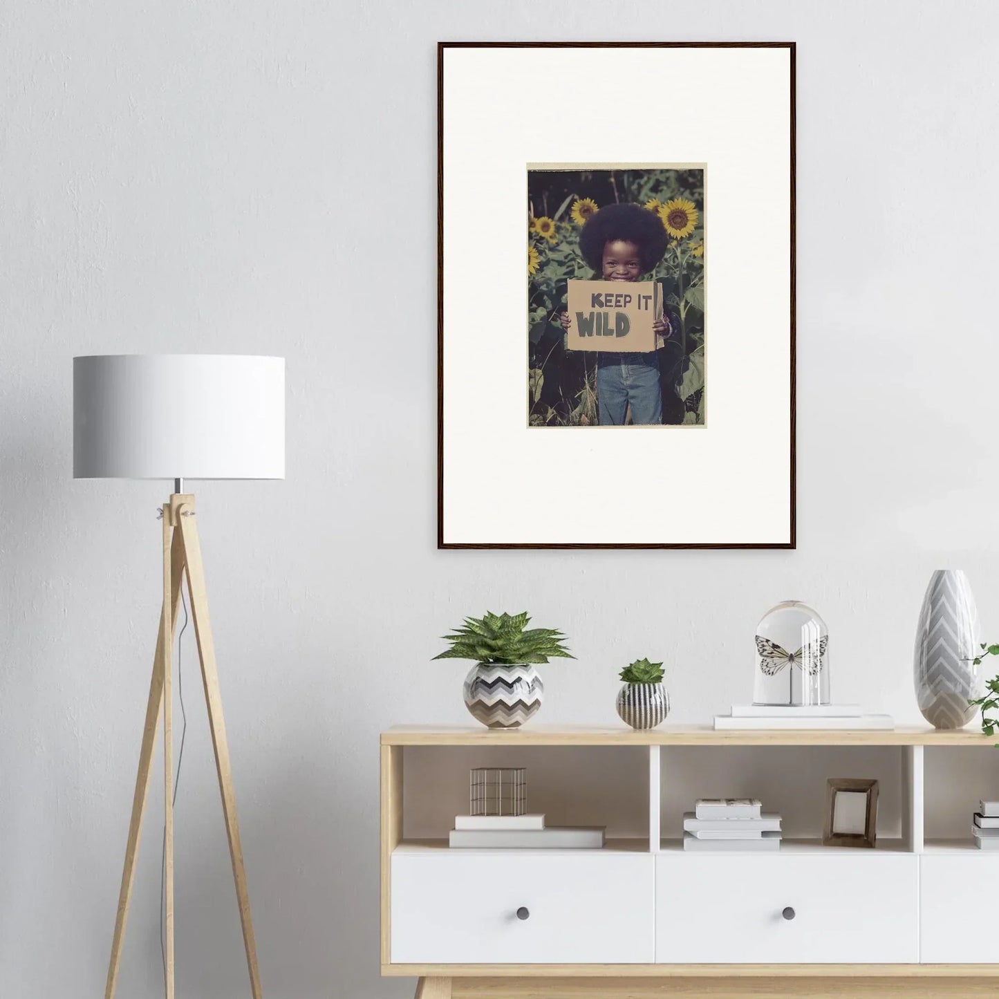 Framed photo of a person with a Keep It Wild sign and sunflowers for room decoration