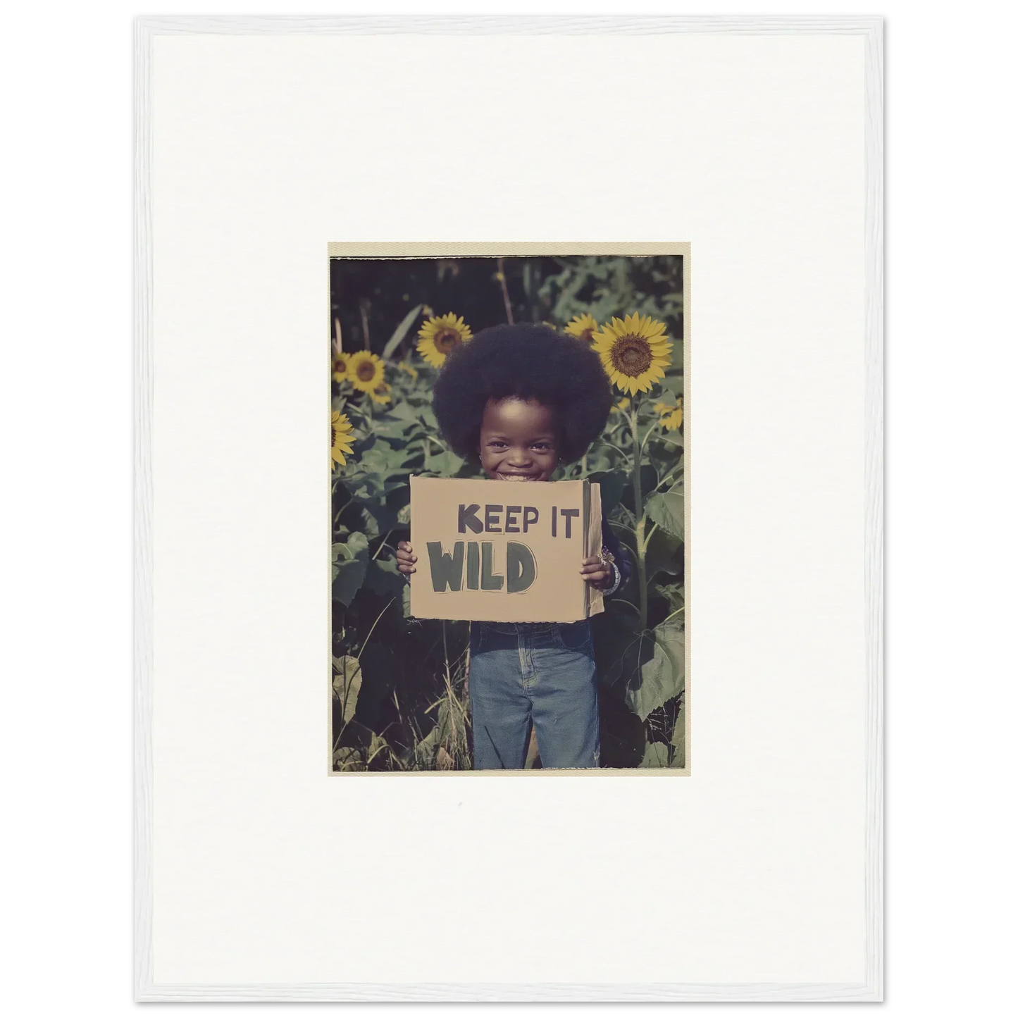 Framed photograph of a child with a KEEP IT WILD sign among sunflowers for room decoration