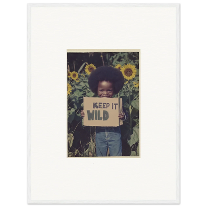 Framed photograph of a child with a KEEP IT WILD sign among sunflowers for room decoration