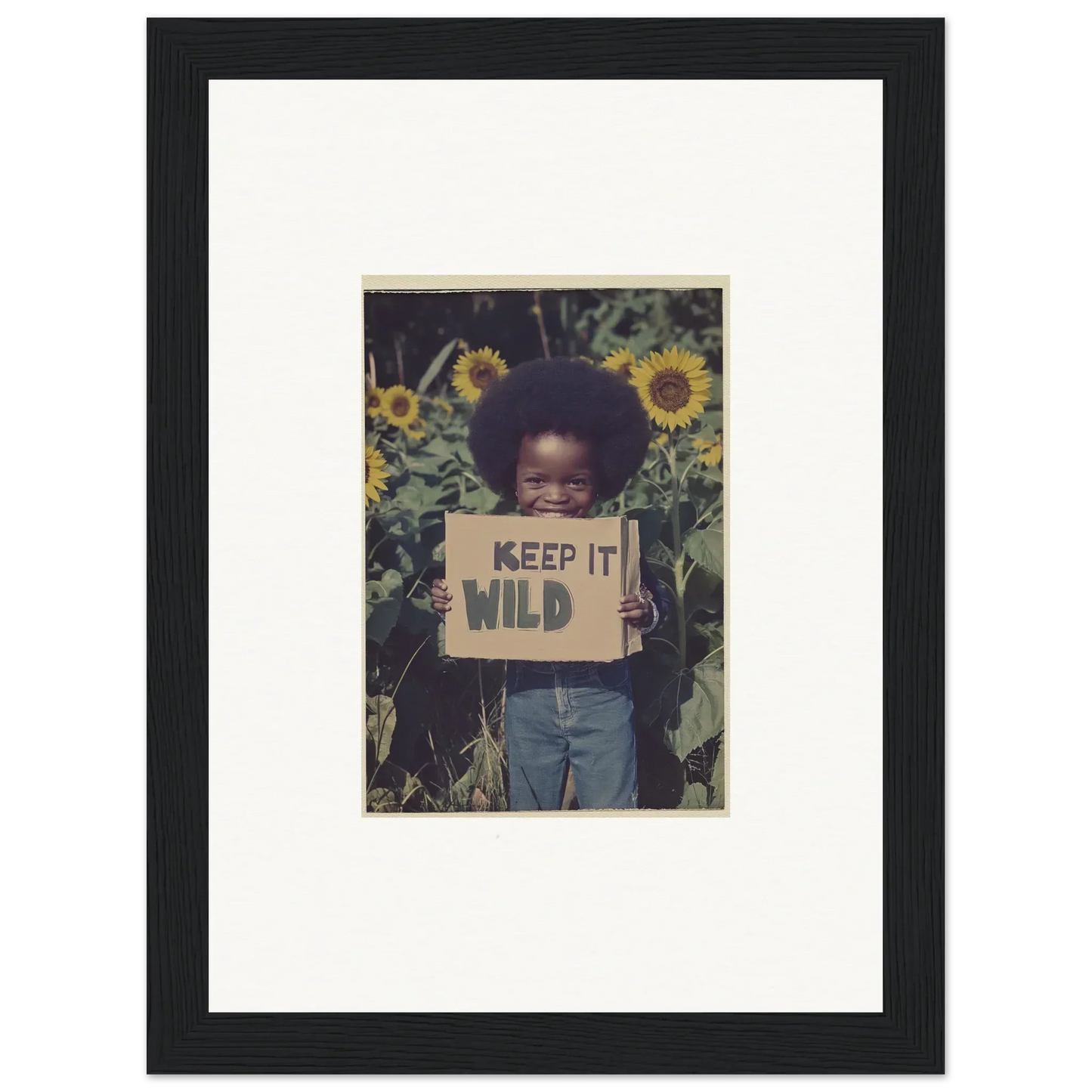 Framed canvas print of a child with a KEEP IT WILD sign among sunflowers, perfect room decoration