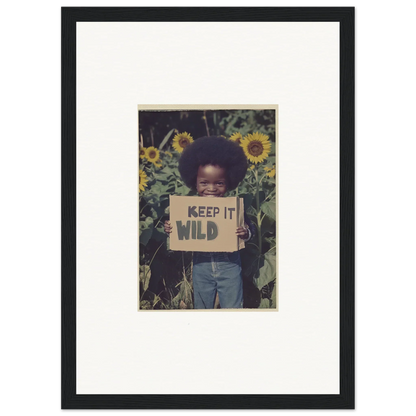 Framed canvas print of a child with a KEEP IT WILD sign in a sunflower field