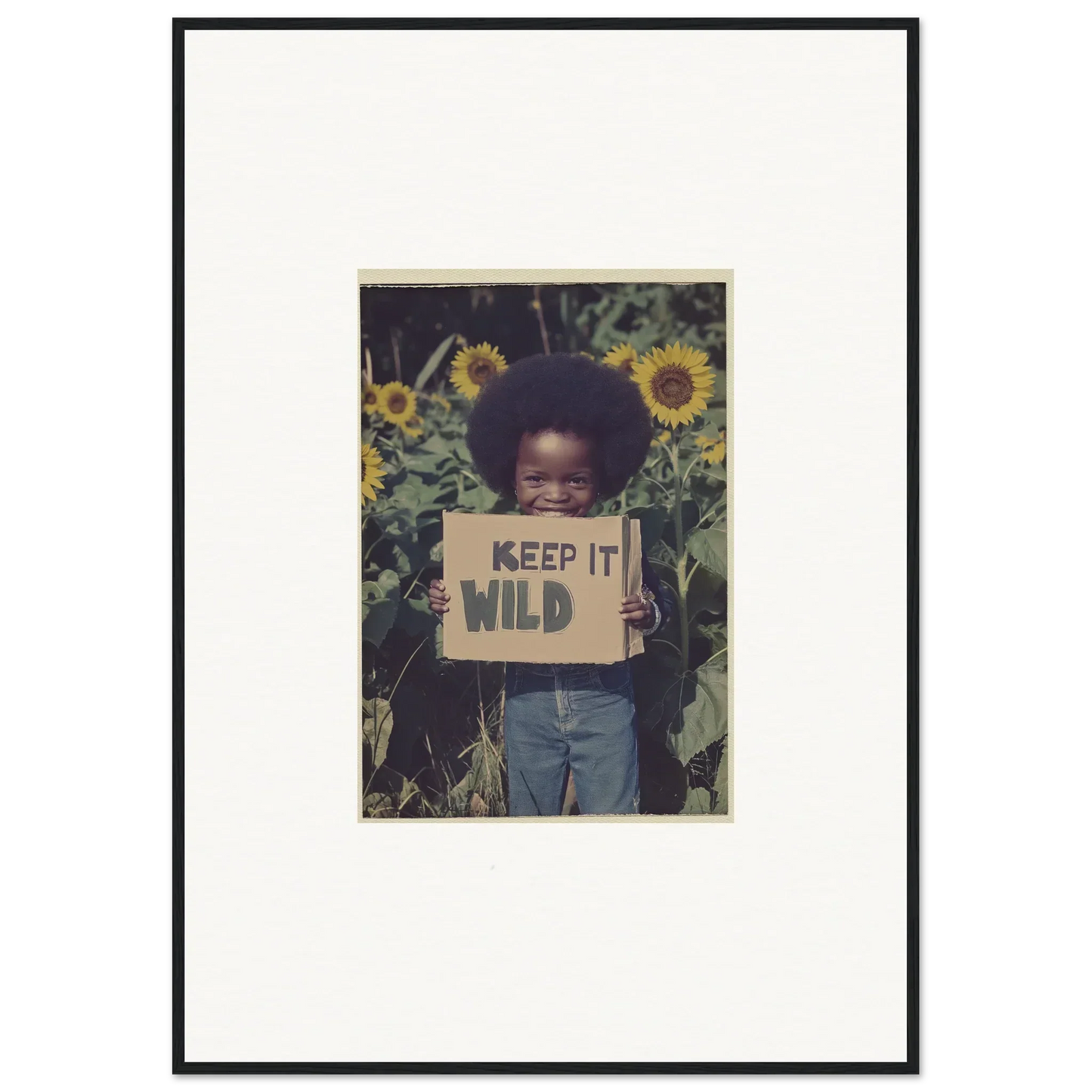 Framed photo of a kid with a KEEP IT WILD sign among sunflowers for room decoration