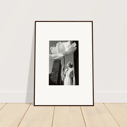 Framed black and white photograph showing a person standing beneath an oversized flower against a cityscape.