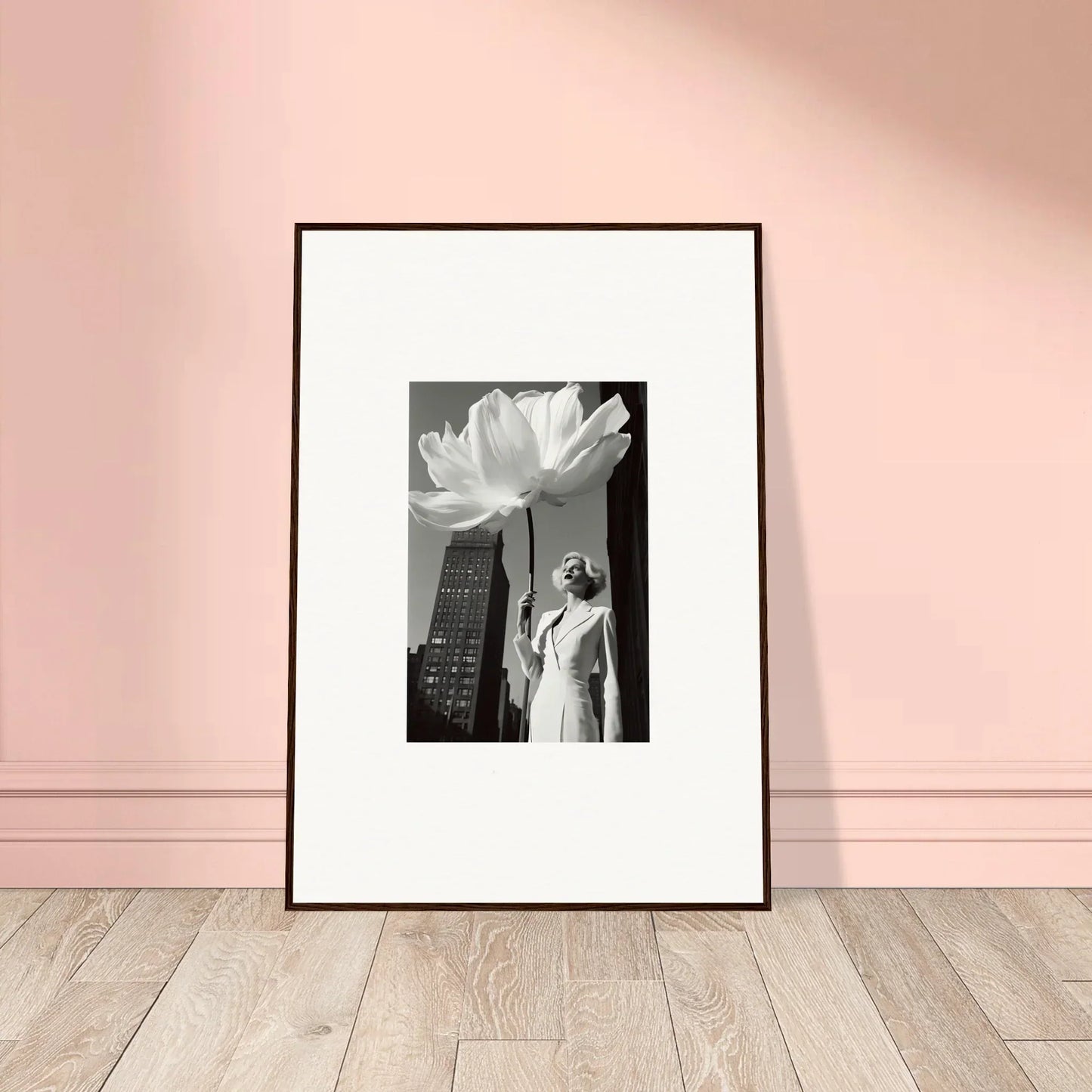 Framed black and white photograph showing a figure against a cityscape with a large flower overlay.