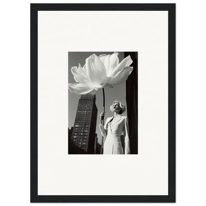 Black and white photograph of a woman standing next to an oversized flower in an urban setting.