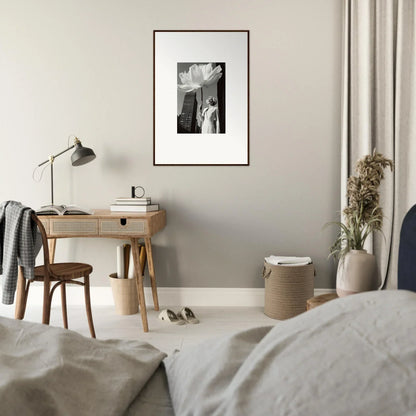 Cozy bedroom workspace with a wooden desk, chair, and framed artwork.