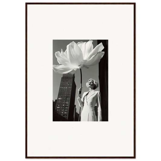 Framed black and white photograph showing a woman standing beneath an oversized flower against a cityscape.