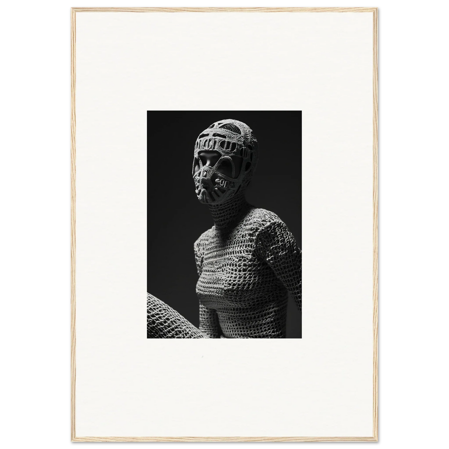 Black and white photograph of a figure wearing a mask and textured, woven clothing.