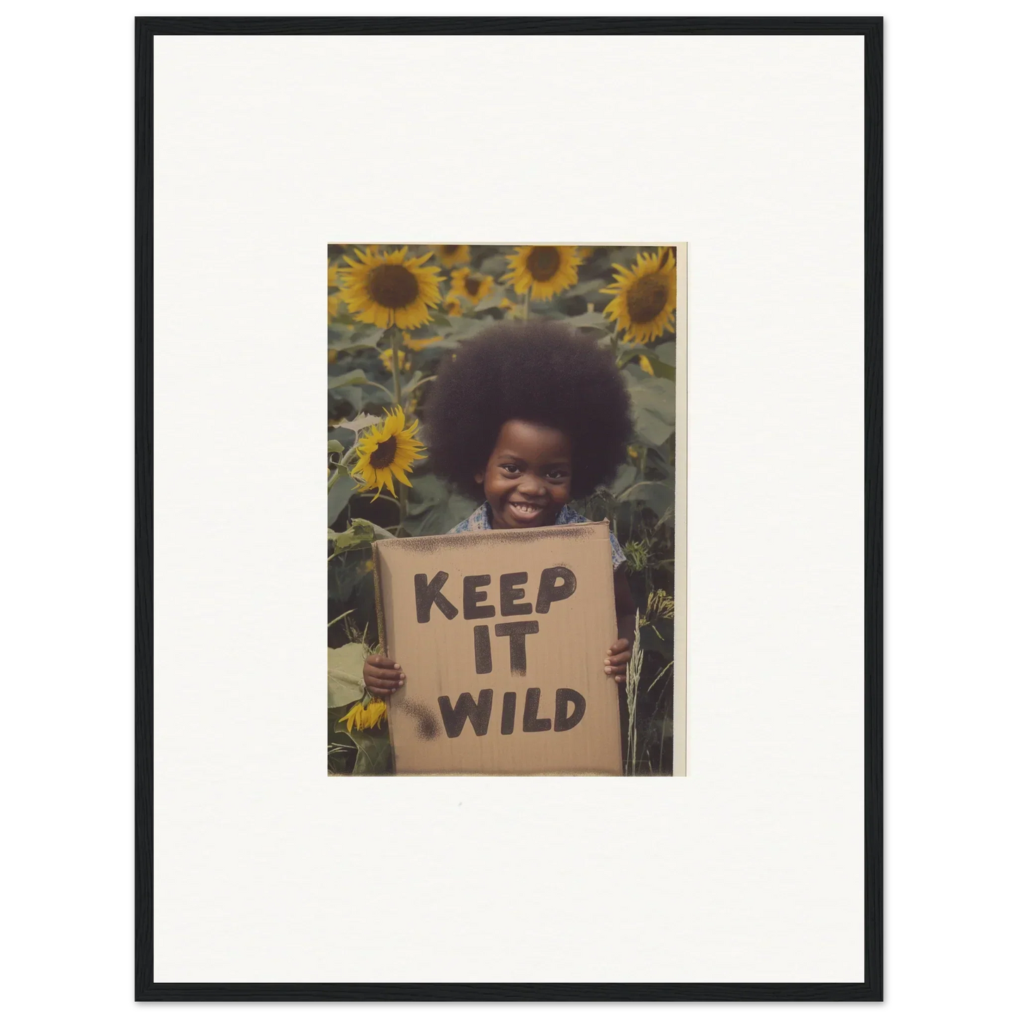 Framed photo of someone with a KEEP IT WILD sign among sunflowers, Visions Bloom Exuberance