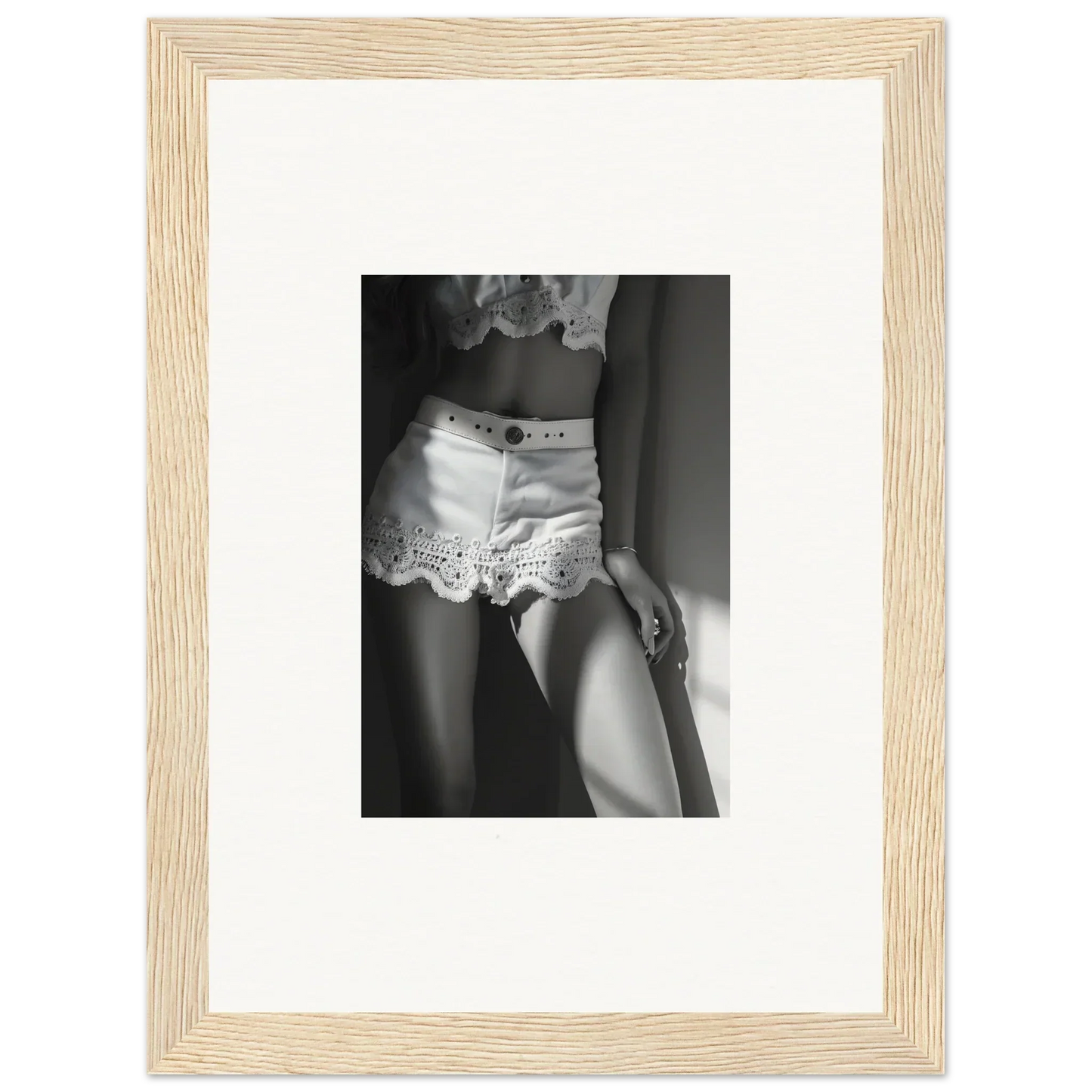 Black and white photograph of a woman’s lower torso wearing lace-trimmed shorts.