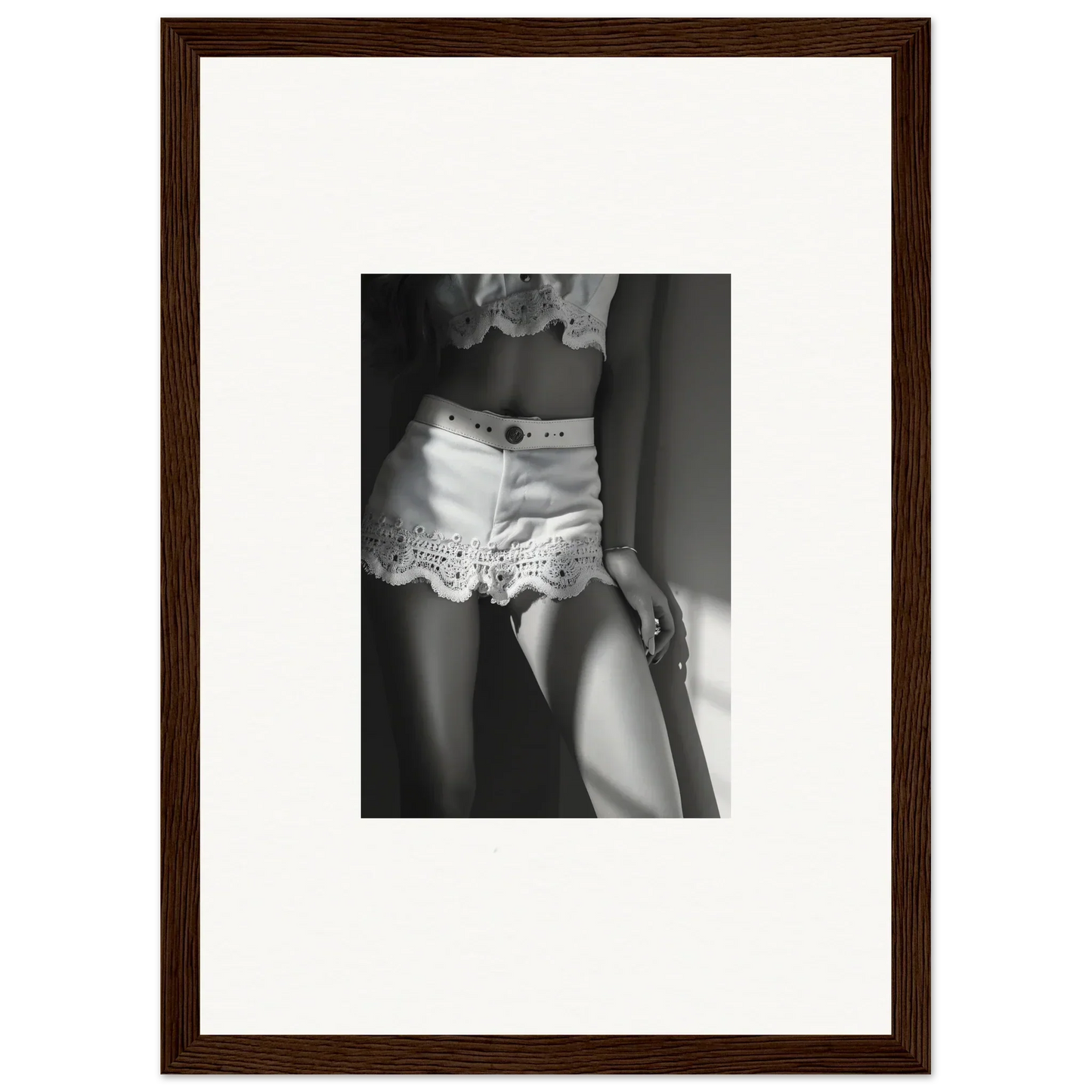 Framed black and white photograph showing a woman’s torso wearing lace-trimmed shorts.