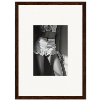 Framed black and white photograph showing a woman’s torso wearing lace-trimmed shorts.