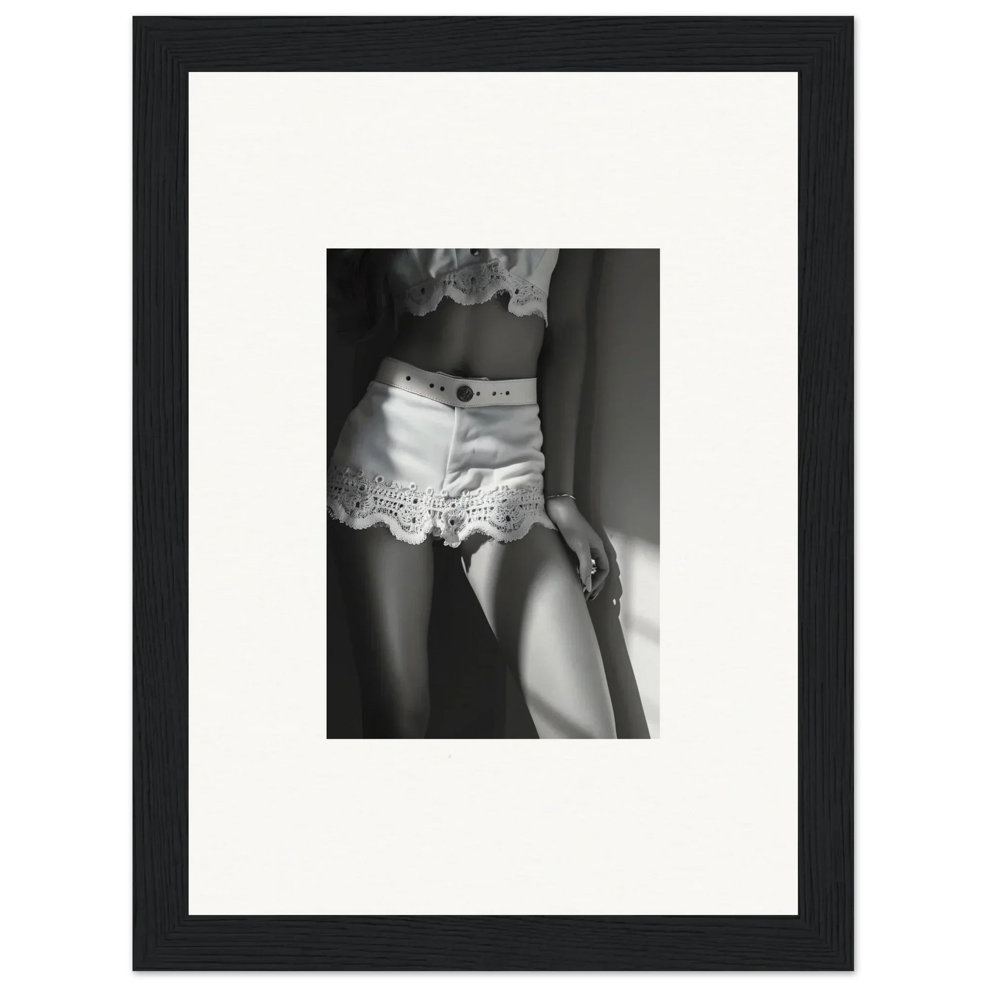 Black and white photograph of a woman’s lower torso wearing lacy white shorts.