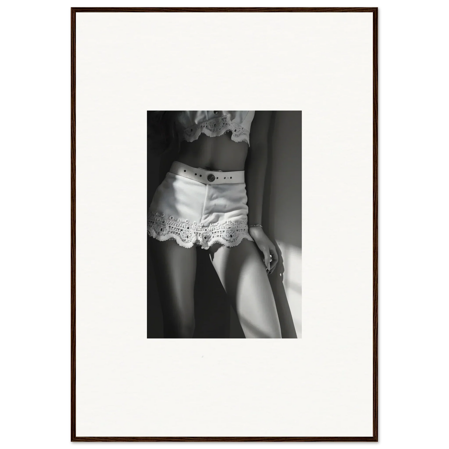 Framed black and white photograph showing a woman’s lower torso wearing lacy white shorts.