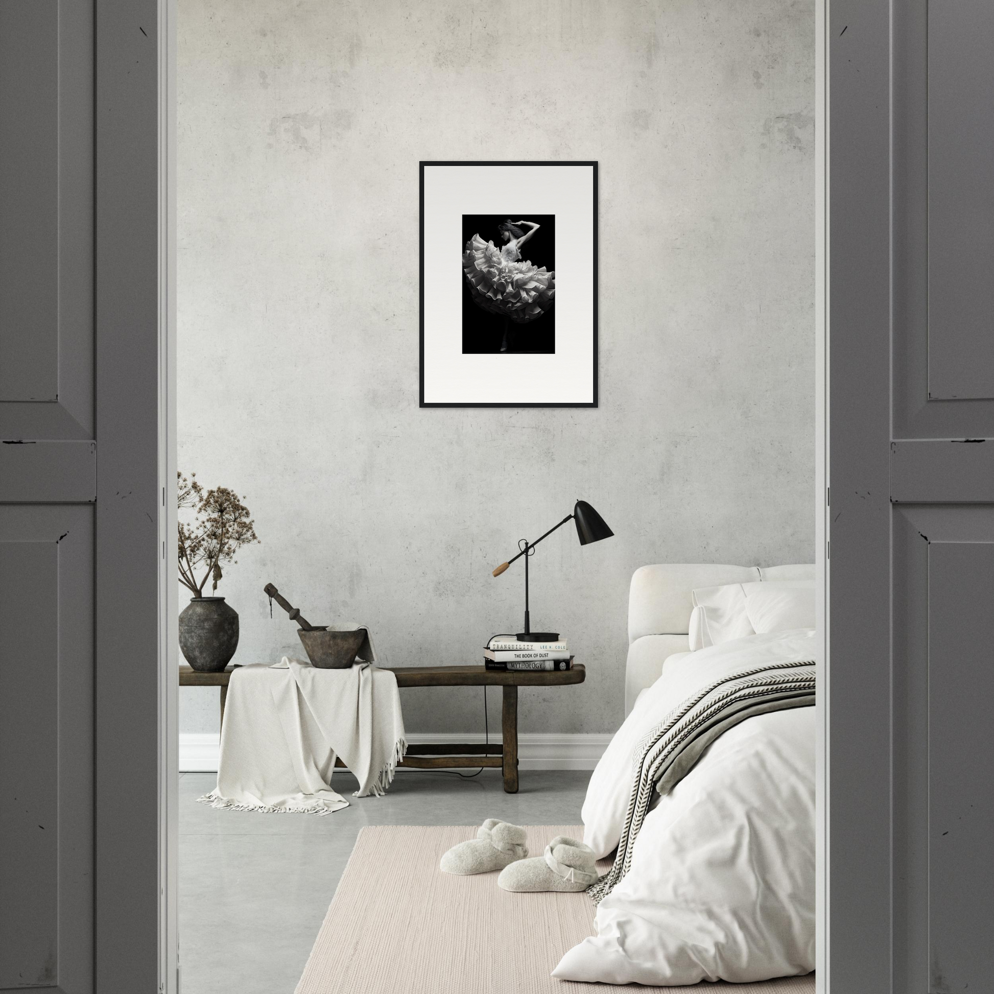 Minimalist bedroom with a monochromatic color scheme and framed artwork.