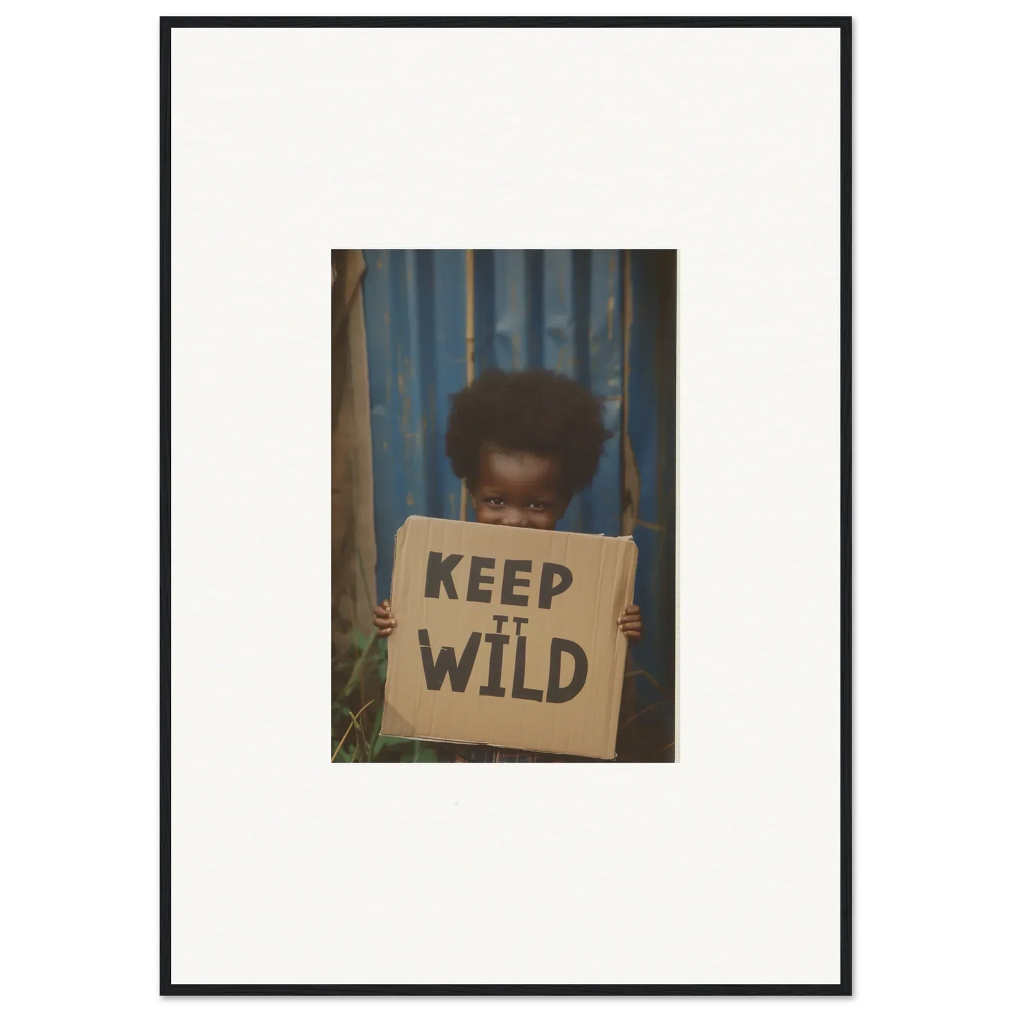 Framed photograph of a person holding a KEEP IT WILD sign for room decoration