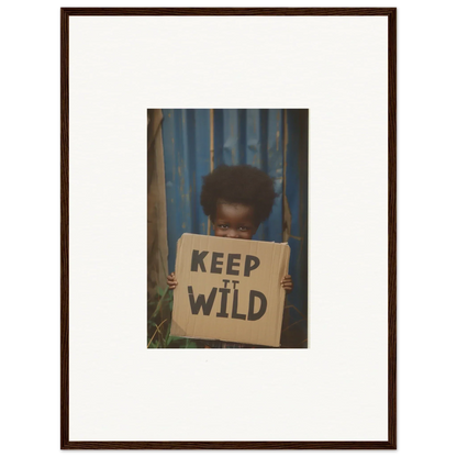 Framed photograph of person with KEEP IT WILD sign, perfect for room decoration or canvas print