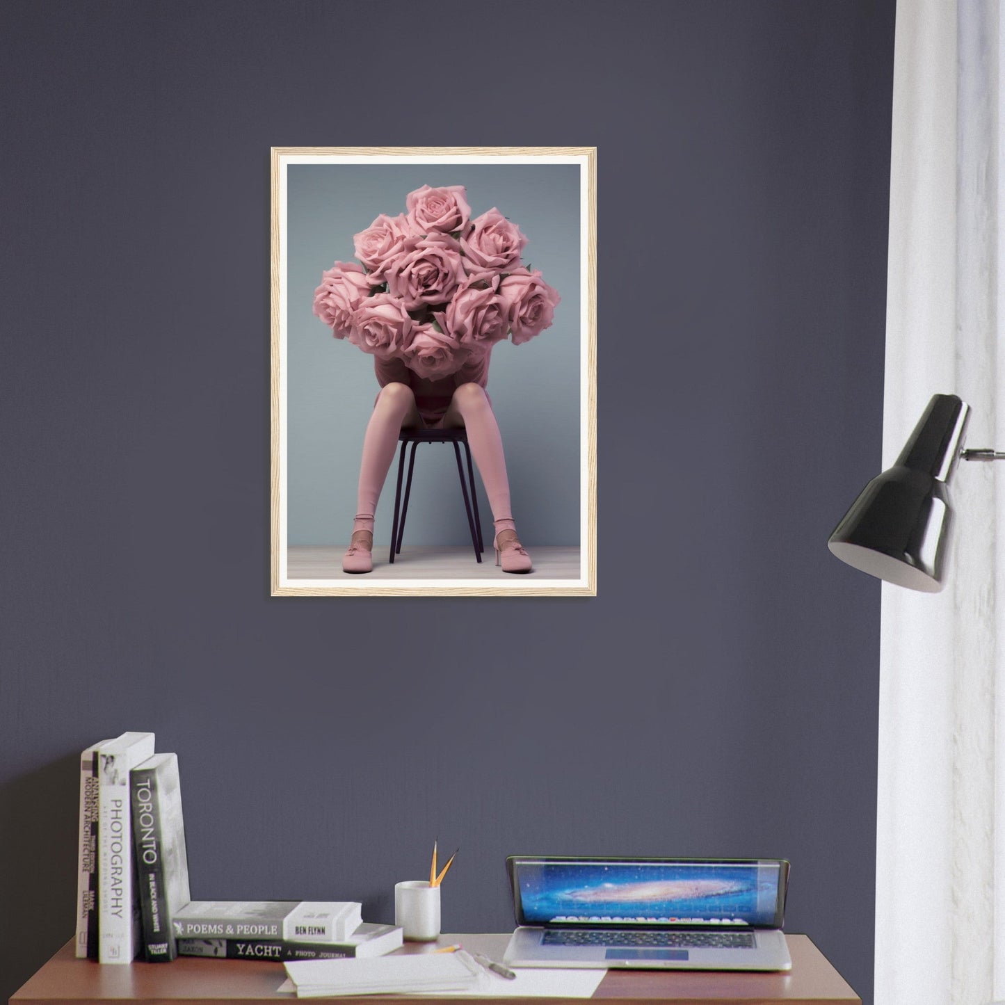 A framed print of a pink flower arrangement on a desk