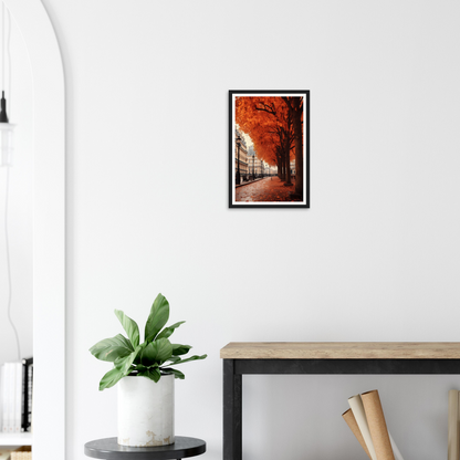 A framed print of a street scene with a red tree in the fore