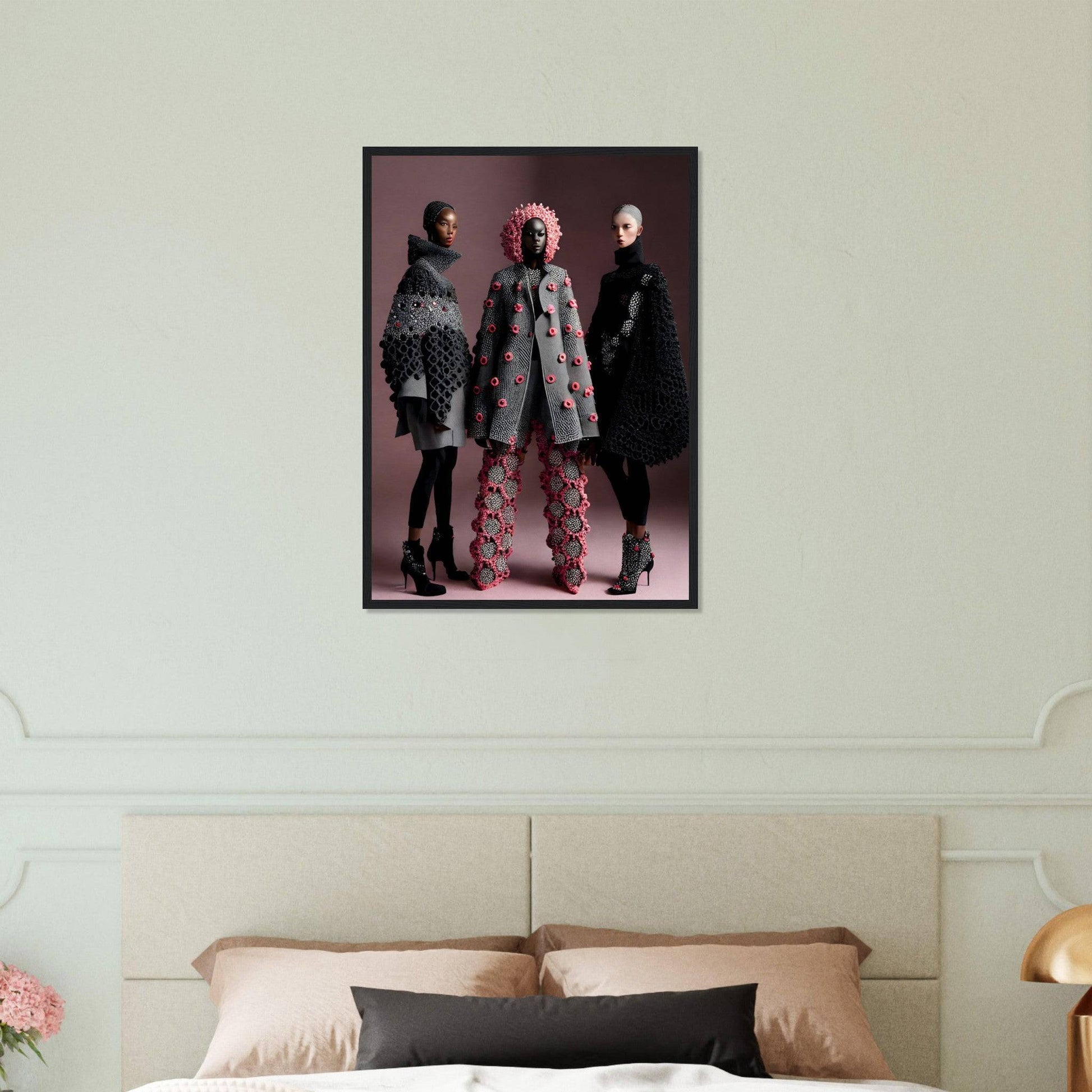 Framed fashion photograph featuring three models in avant-garde outfits against a pink backdrop.