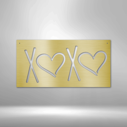 Gold-colored metal plate with ’XOXO’ cut out in a stylized design featuring hearts.