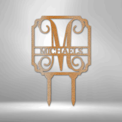 Decorative gold-colored cake topper featuring the letter ’M’ and the name ’MICHAELS’ in an ornate design.