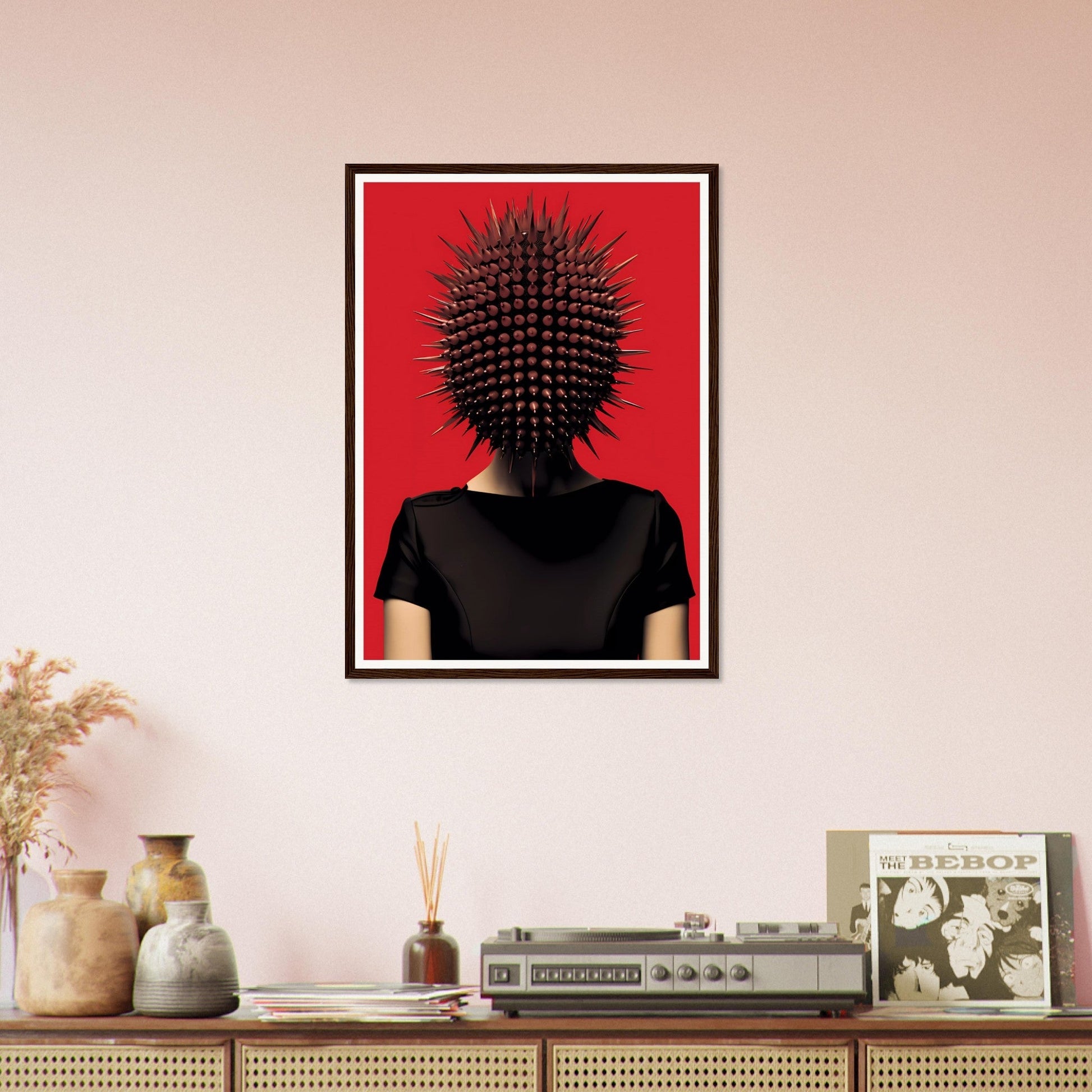 Framed artwork depicting a figure with a spiky, spherical head against a red background.