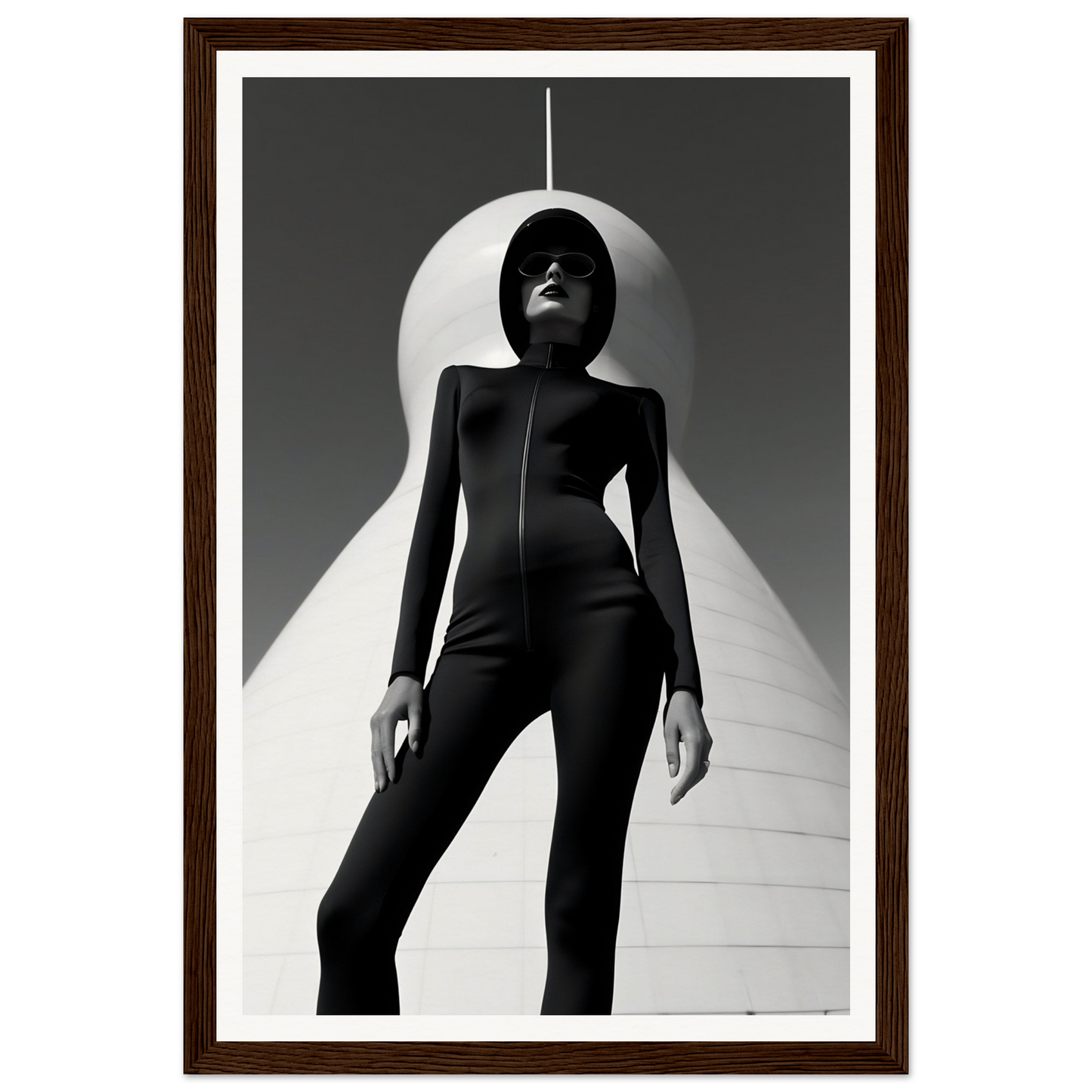 Silhouette of a person in a sleek, form-fitting black outfit standing dramatically against a white backdrop.