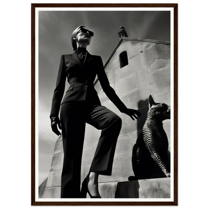 Woman in a tailored pantsuit striking a dramatic pose next to a stylized cat sculpture.