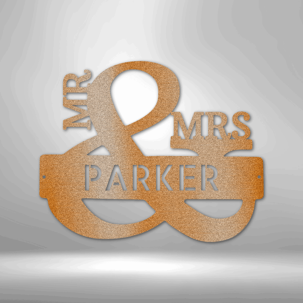 Gold-colored metal sign reading ’MR & MRS PARKER’ with an ampersand symbol as the focal point.