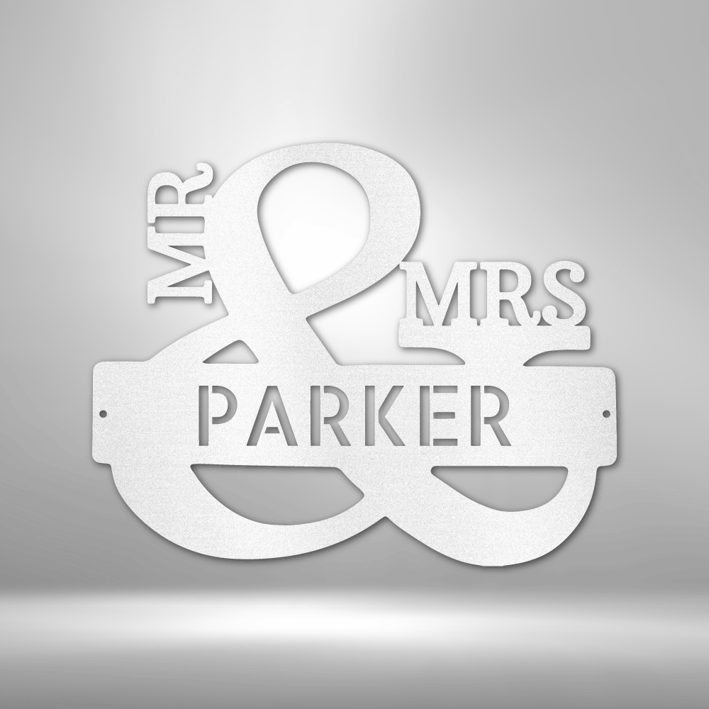 White metal or plastic sign reading ’MR & MRS PARKER’ with an ampersand symbol.