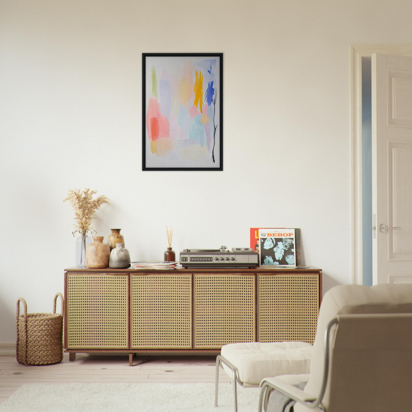 Wooden sideboard with cane-webbed doors and decorative items above a framed canvas print