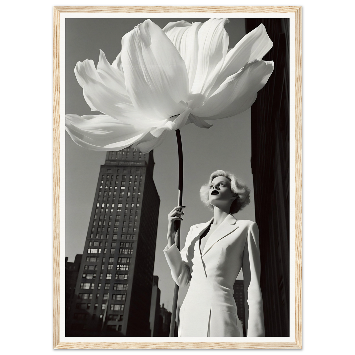 Woman in a white dress holding an oversized flower against an urban backdrop.