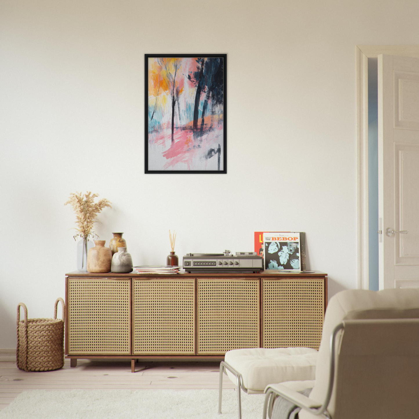 Wooden sideboard with rattan front and decorative items above Pink Twilight Trees print