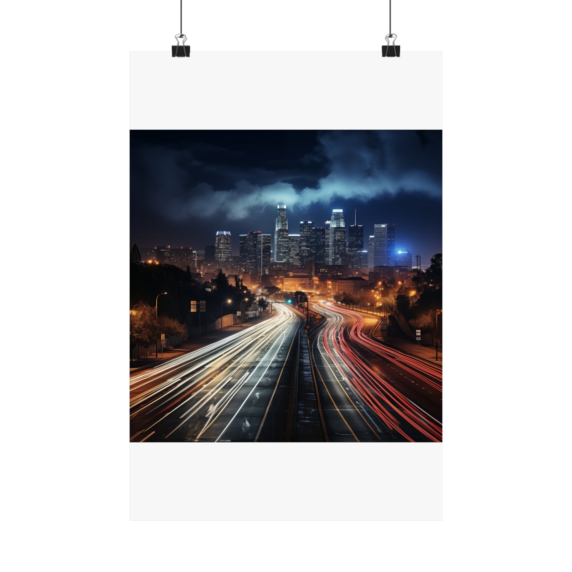 Nighttime cityscape with illuminated skyscrapers and light trails from traffic on a highway.