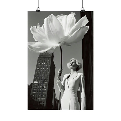 Woman in a white outfit holding an oversized white flower against an urban backdrop.