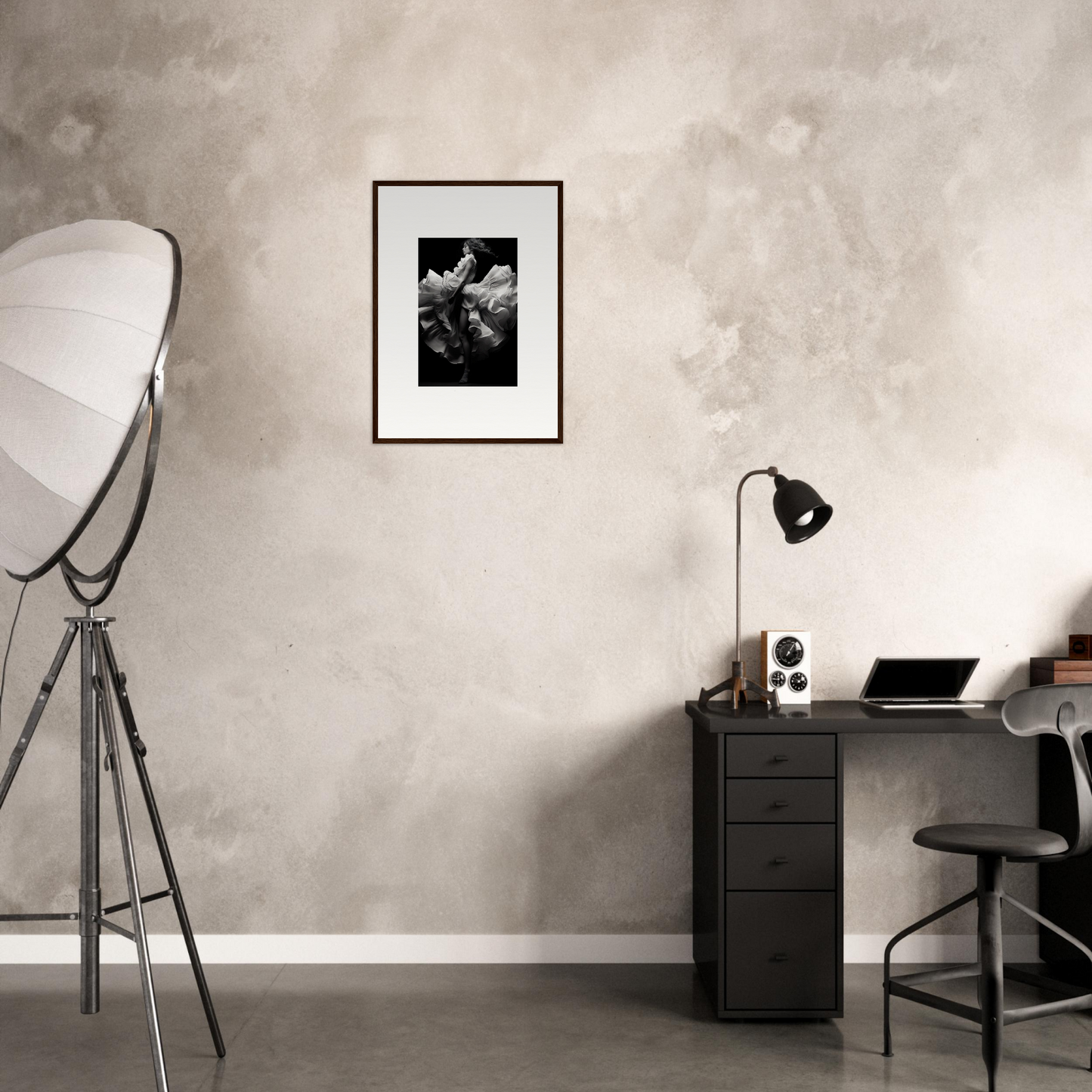 Minimalist home office workspace with a desk, chair, and framed artwork.