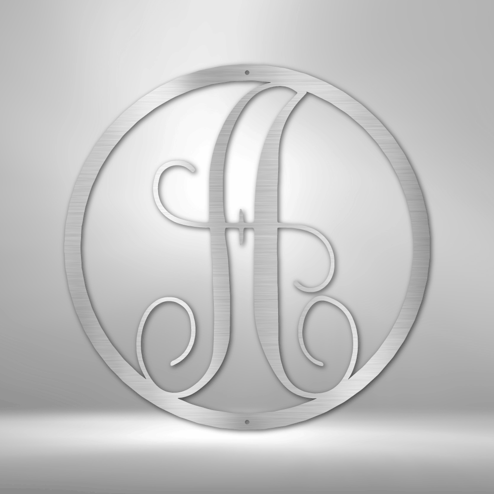 Circular monogram featuring an ornate letter ’A’ in a stylized script design.