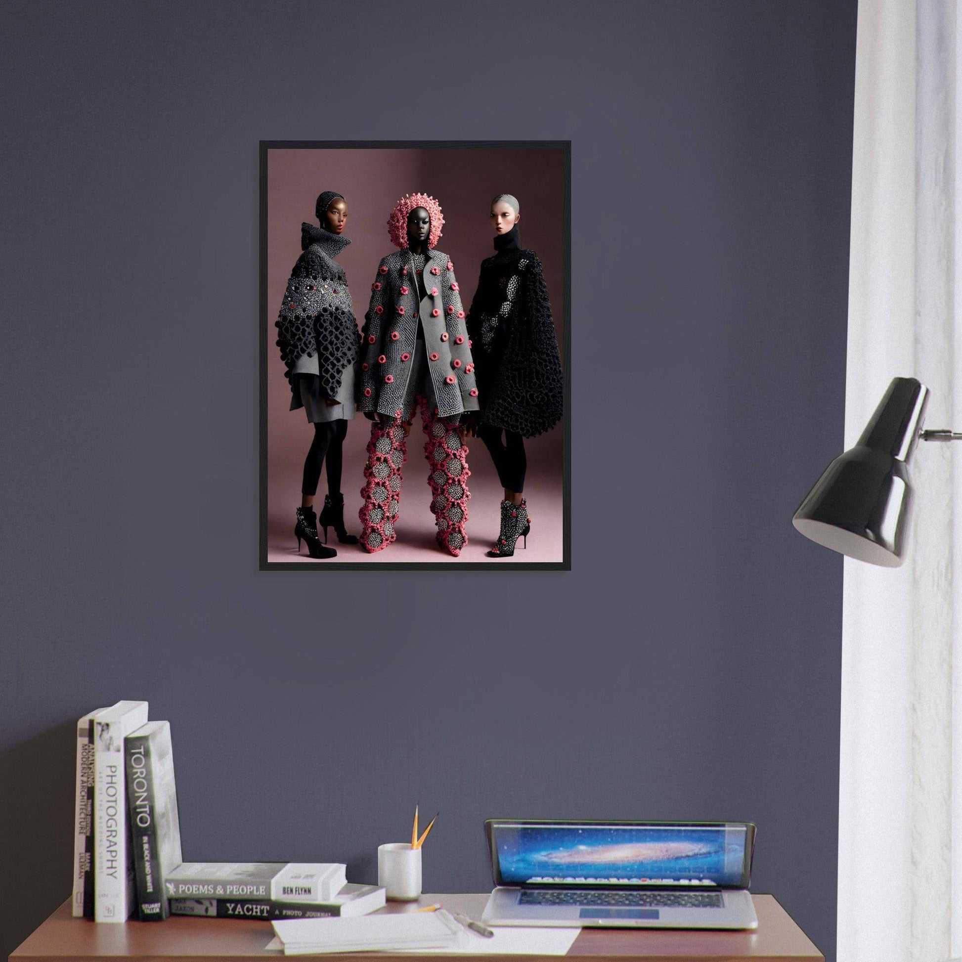 Framed photograph of three people wearing stylish coats and boots against a pink backdrop.