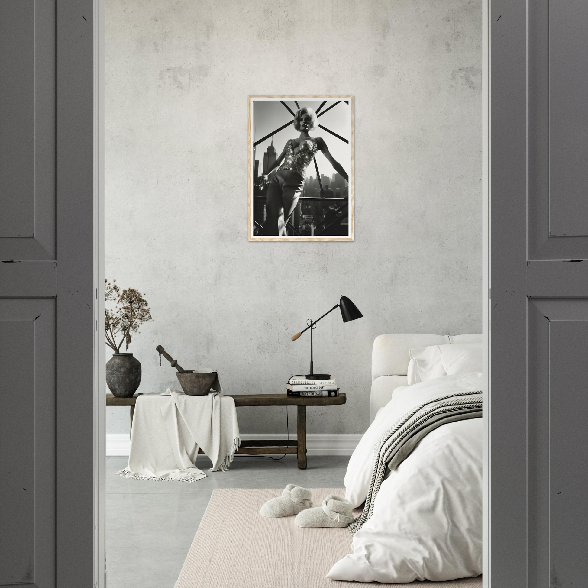 Minimalist bedroom with a black and white photograph on the wall.