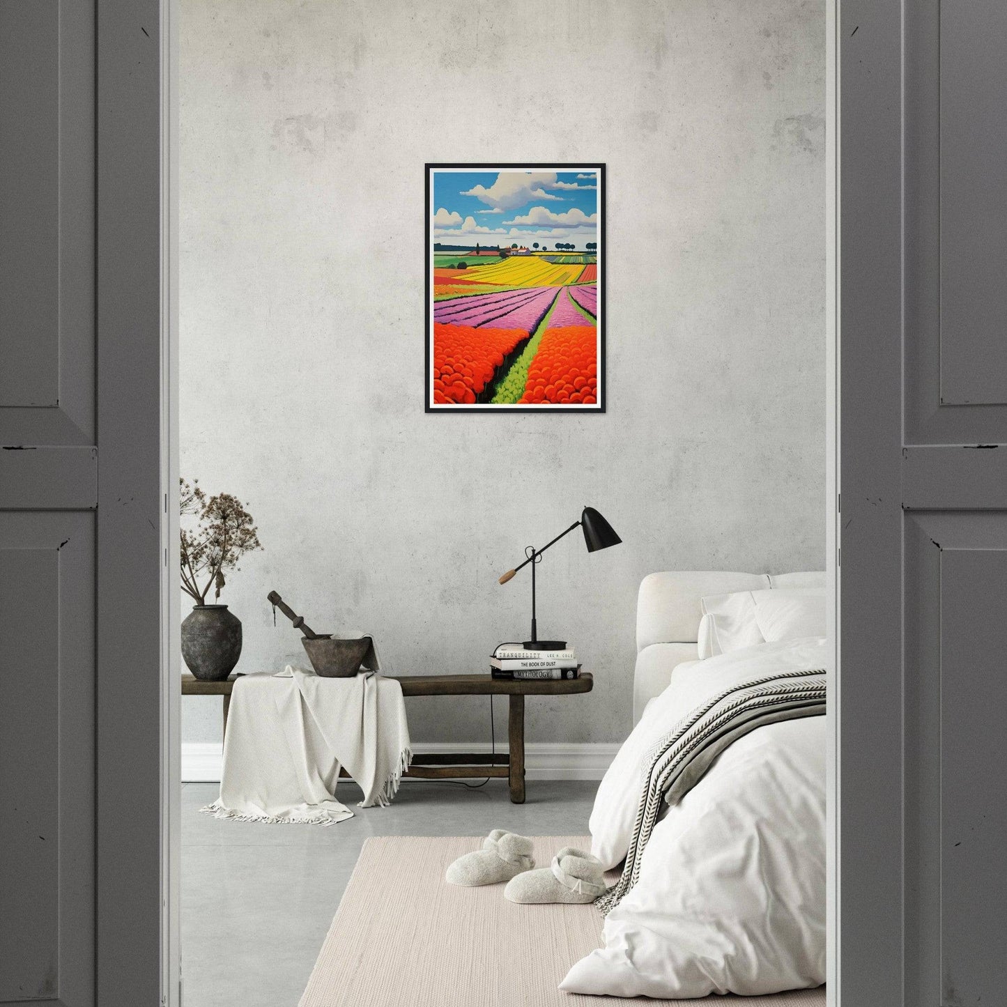 Framed colorful landscape painting of tulip fields hanging on a white wall.