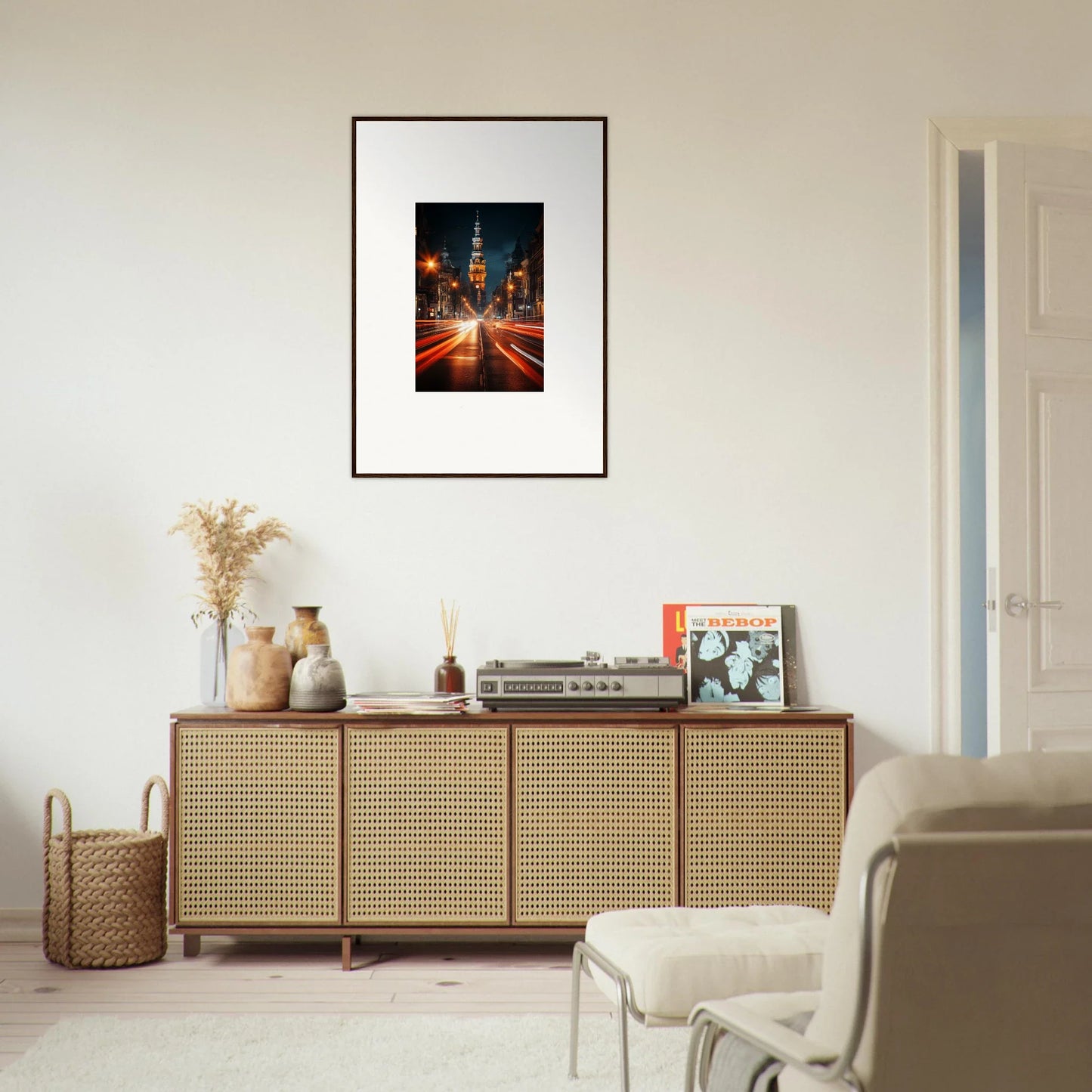 Framed Umbra Urban Nocturne cityscape photo above a stylish rattan credenza