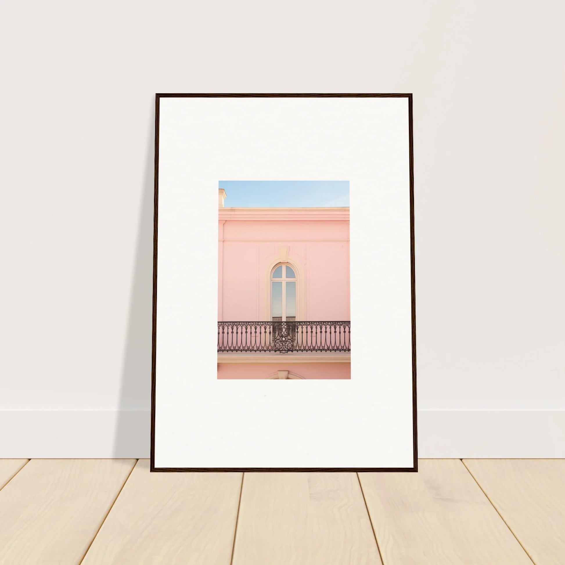 Framed wall art of a peach tranquil portal featuring a pink building’s balcony