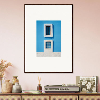 Framed wall art of a blue building wall with white windows from Isles Encompassed Vista