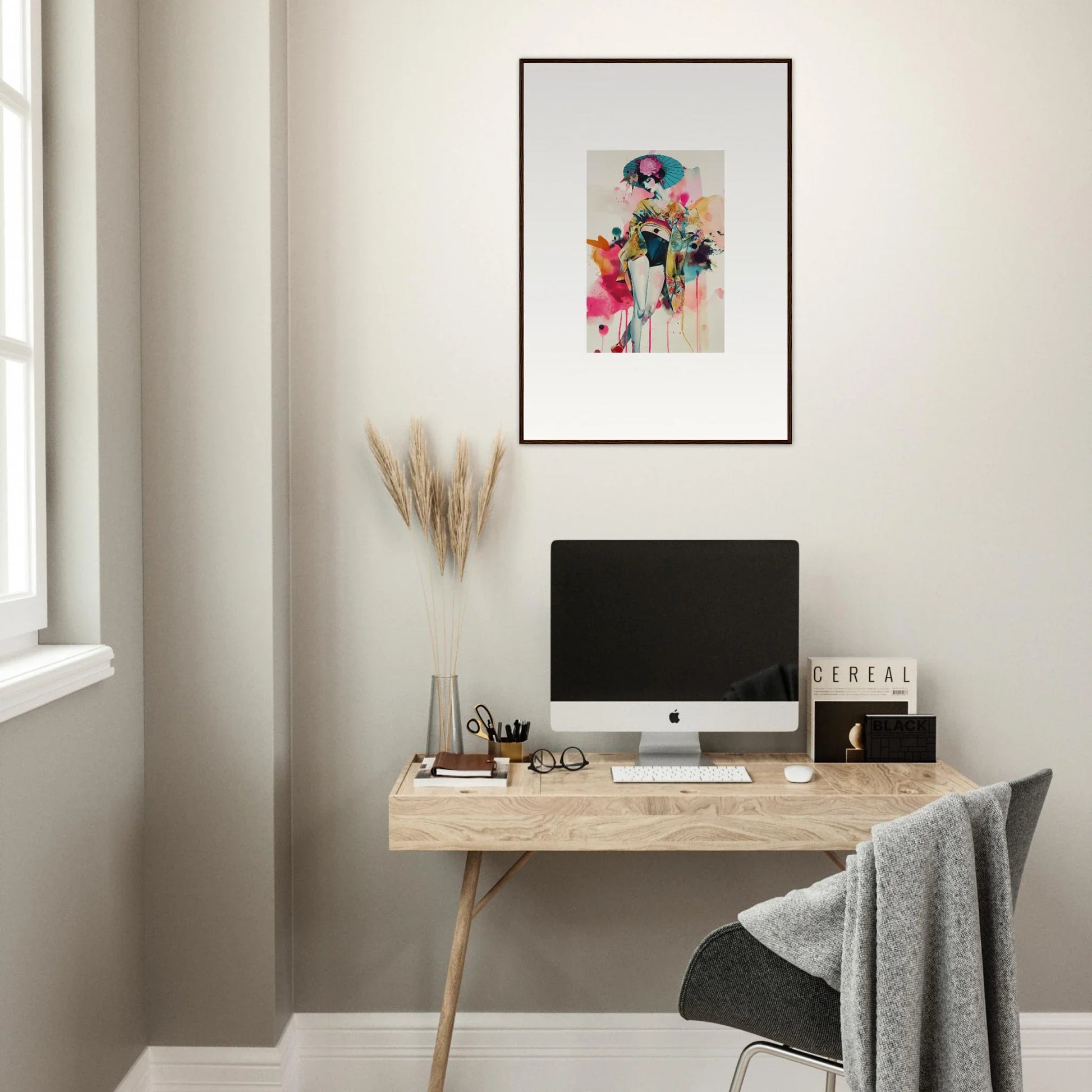 Minimalist wooden desk with a computer, decorative wall art, and canvas print above