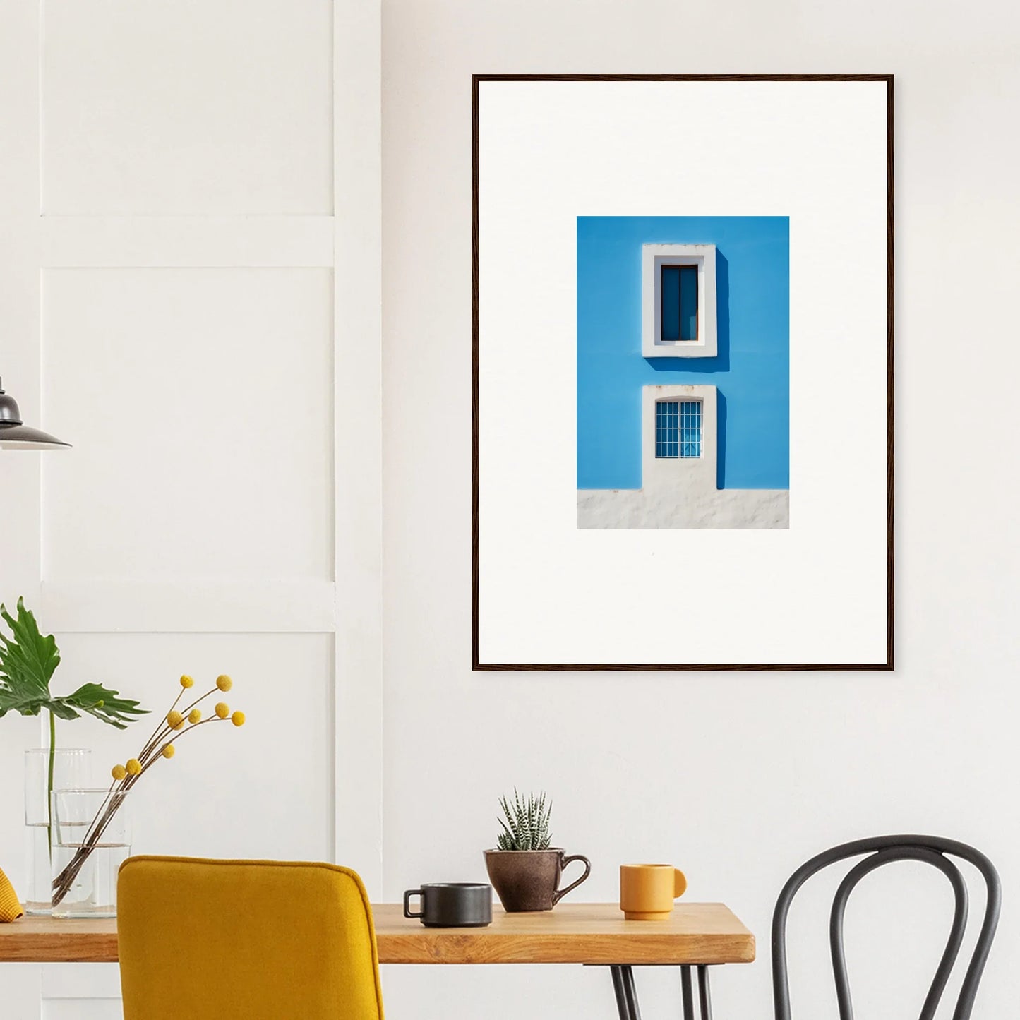 Framed wall art of two white-trimmed windows on a blue wall in Isles Encompassed Vista